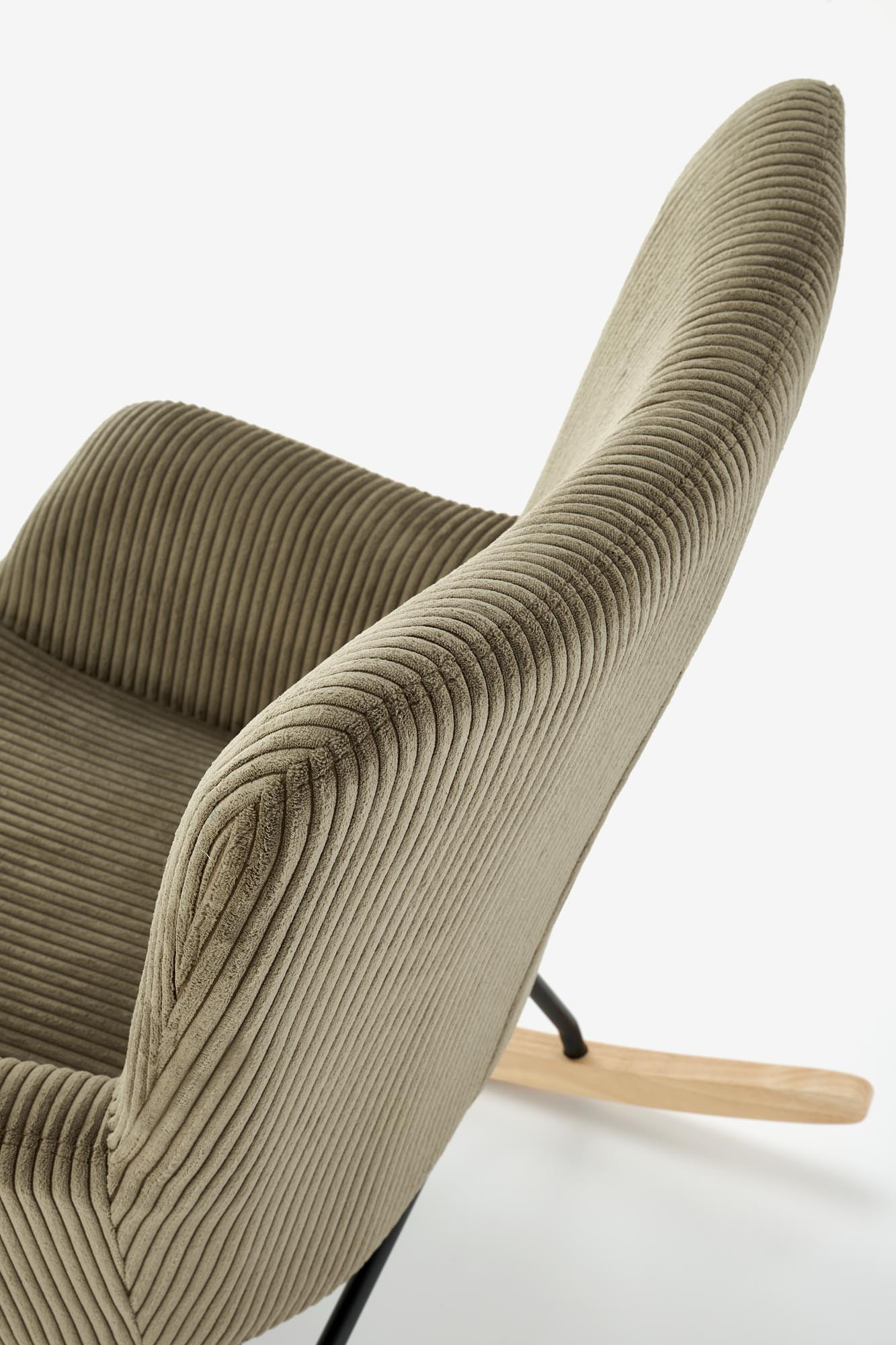 Zbliżenie na oliwkowy fotel wypoczynkowy BELMIRO z sztruksu na płozach.