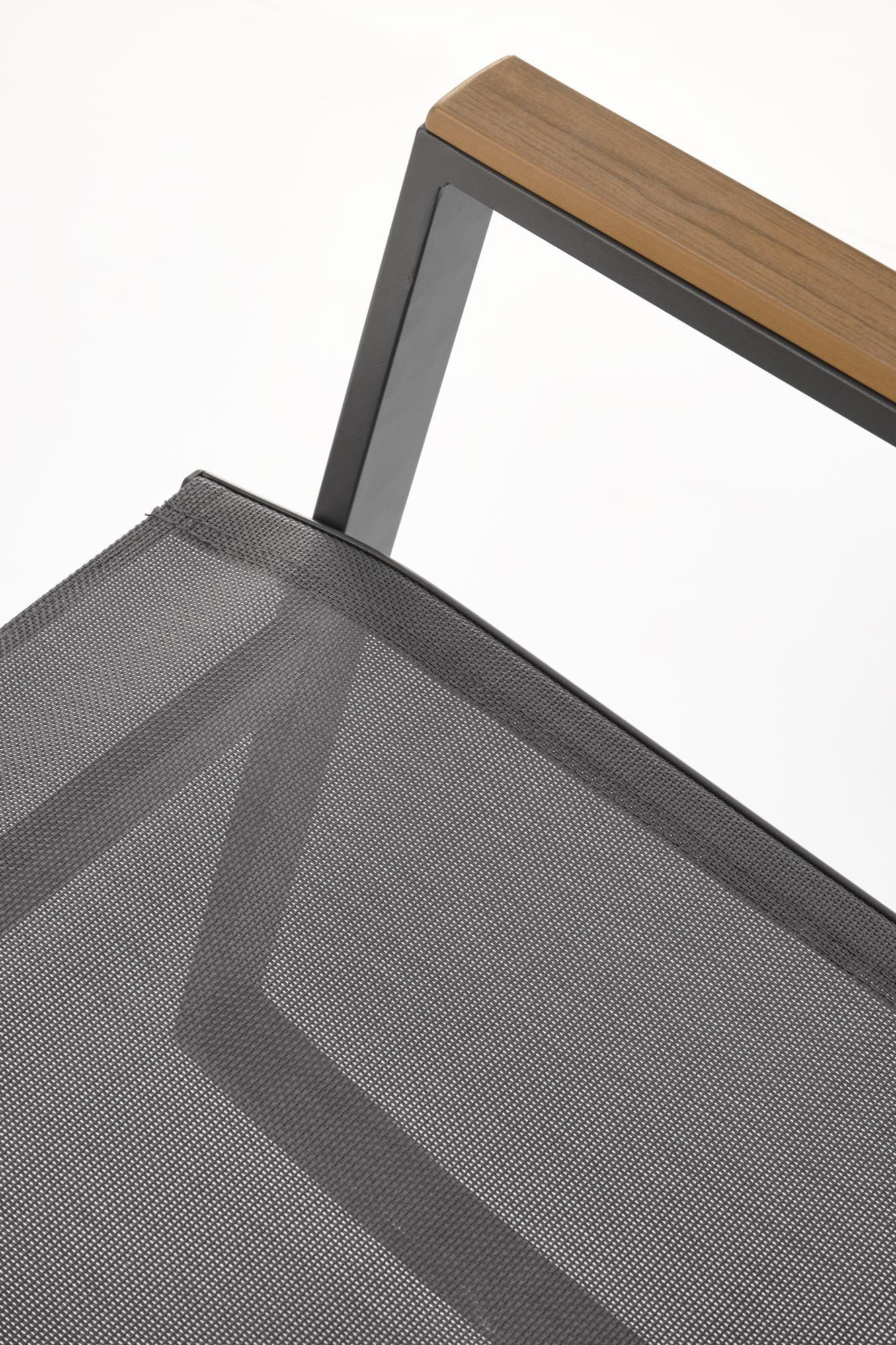Zbliżenie na ciemnoszare siatkowe oparcie i drewniany podłokietnik krzesła ogrodowego ZLATAN.