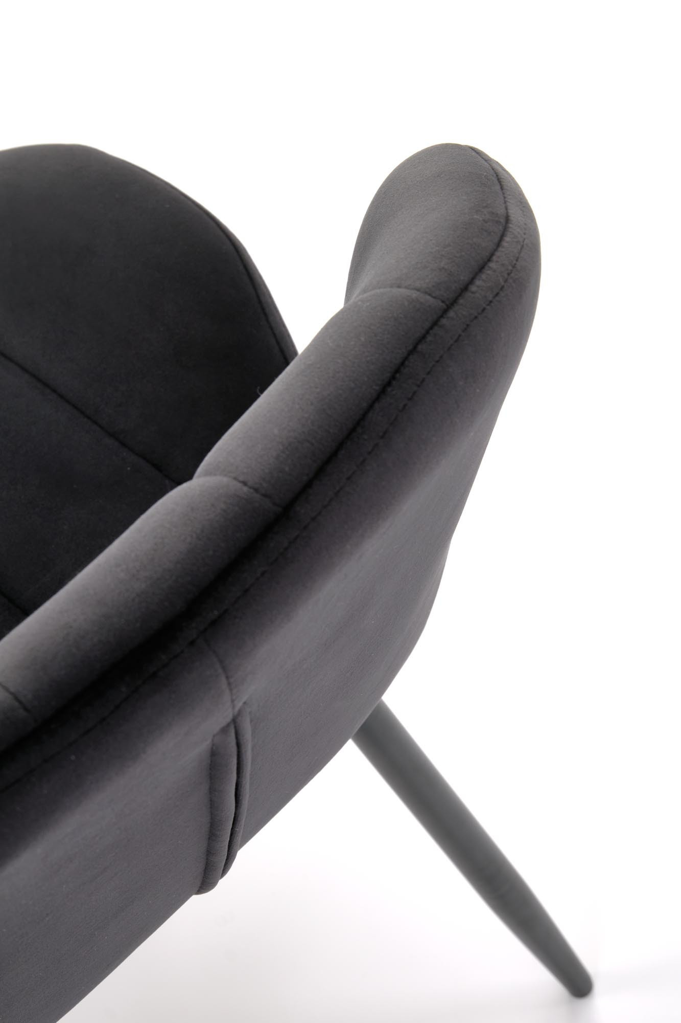 Zbliżenie na kubełkowe oparcie czarnego krzesła K538 z weluru i stalowymi nogami.