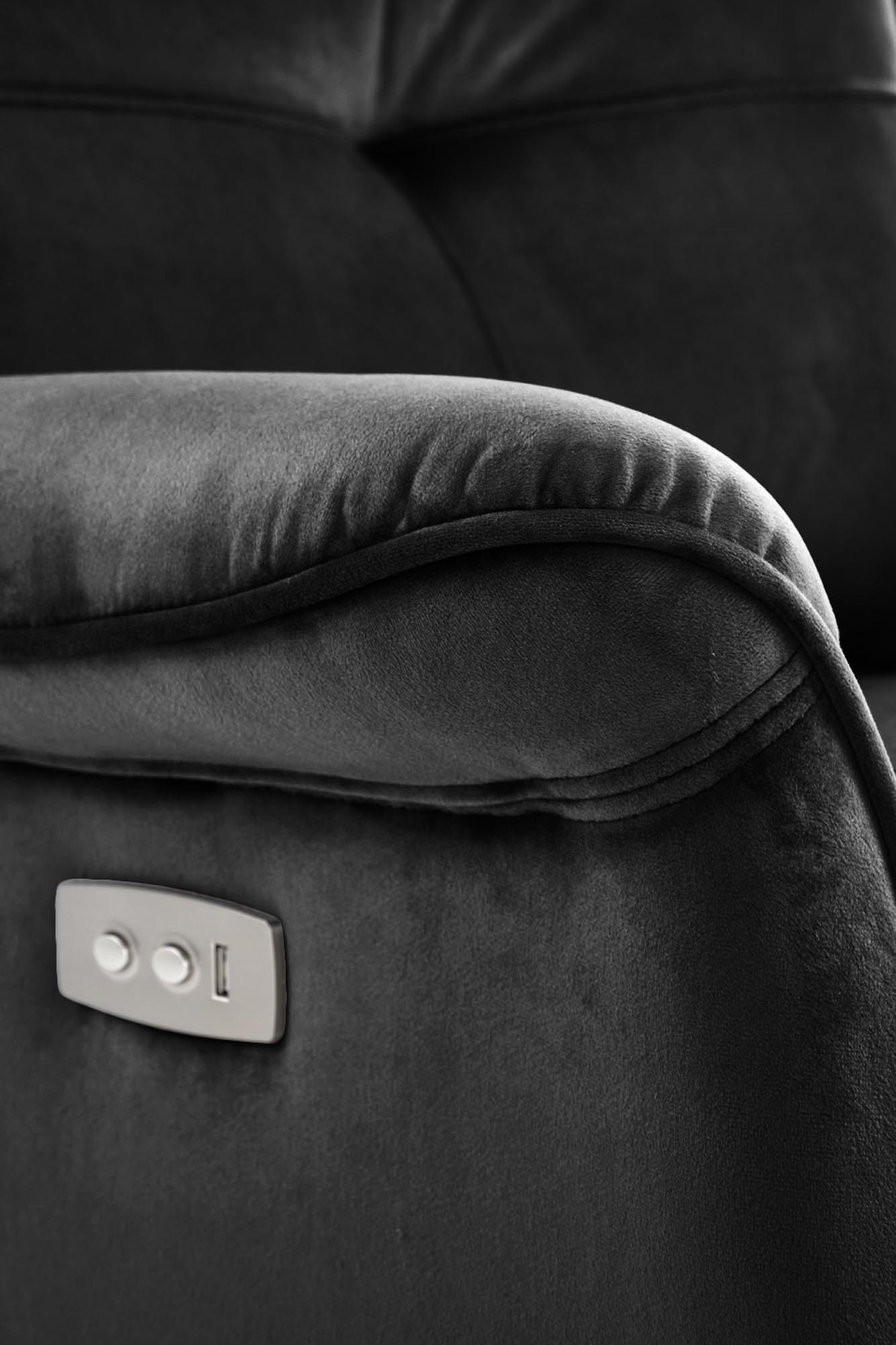Zbliżenie na czarny aksamitny fotel SEMIR z przyciskami elektrycznego rozkładania i gniazdem USB.