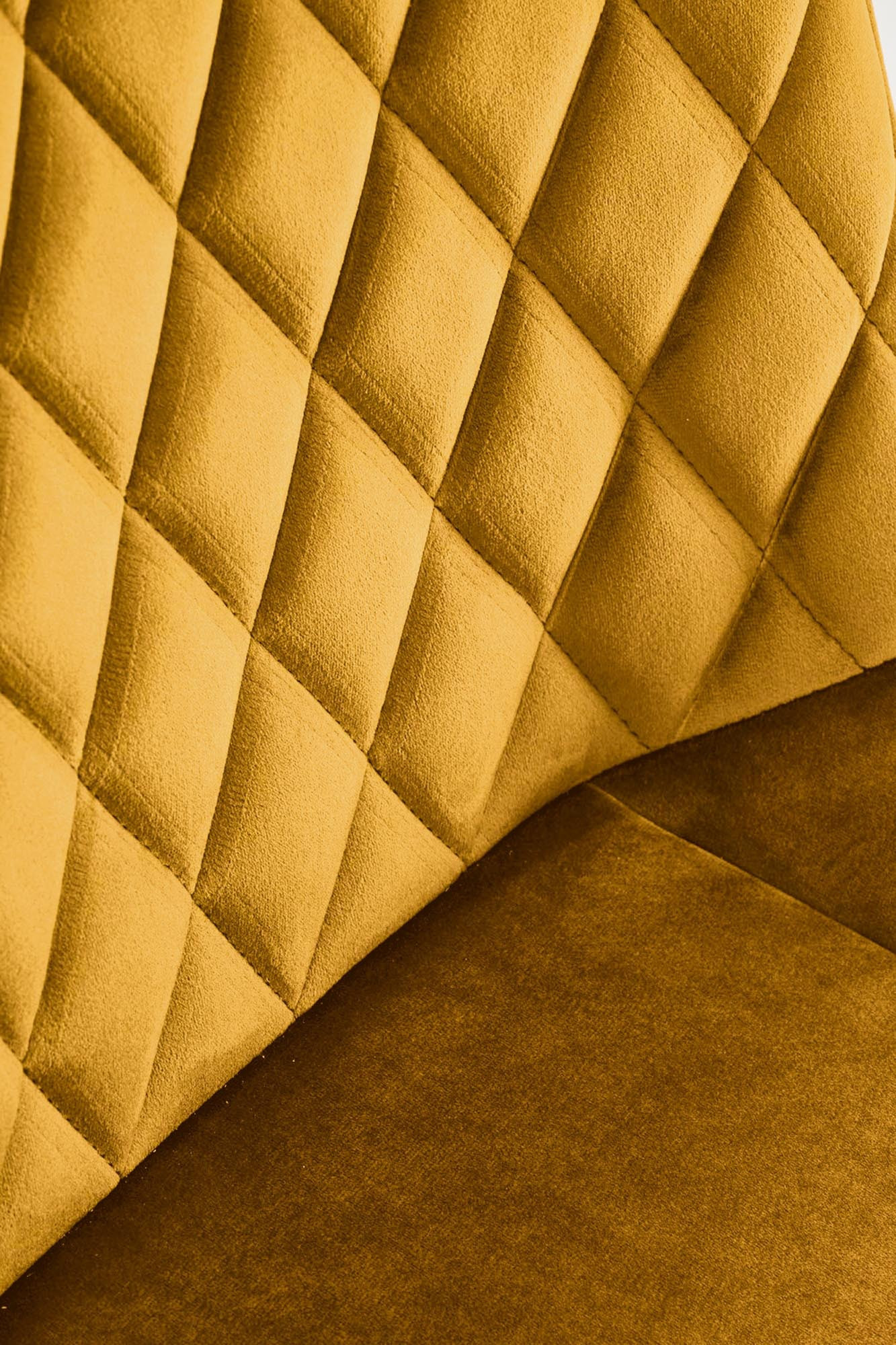 Zbliżenie na pikowane musztardowe oparcie krzesła K520 z weluru.