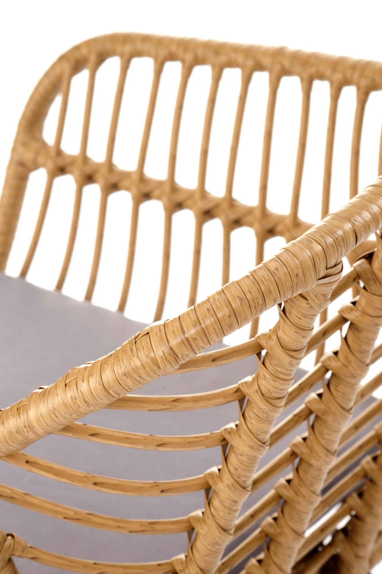 Zbliżenie na rattanowe oparcie i siedzisko krzesła K541 z naturalnego materiału i stalowymi nogami.