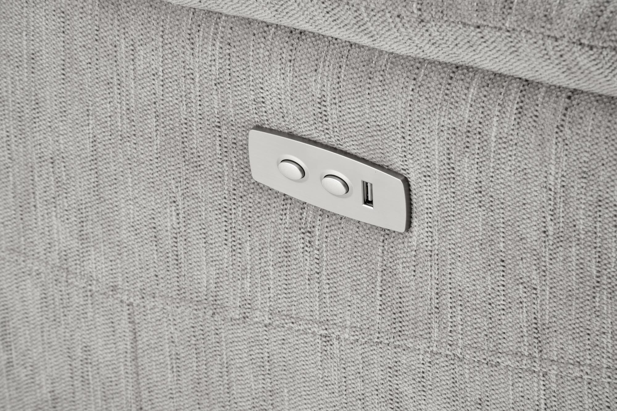 Zbliżenie na popielaty fotel wypoczynkowy JAMAL z elektrycznym mechanizmem rozkładania i portem USB.