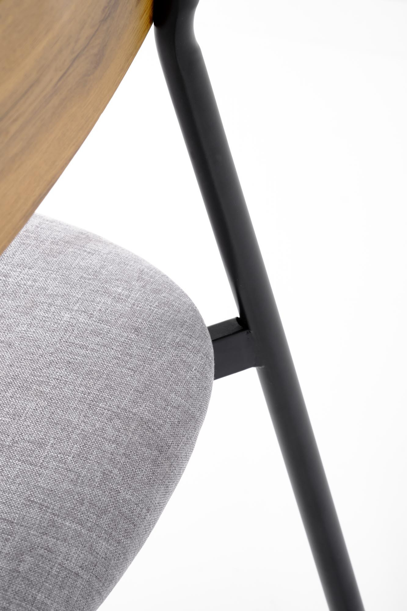 Zbliżenie na szare siedzisko krzesła z metalową ramą z zestawu NANDO.