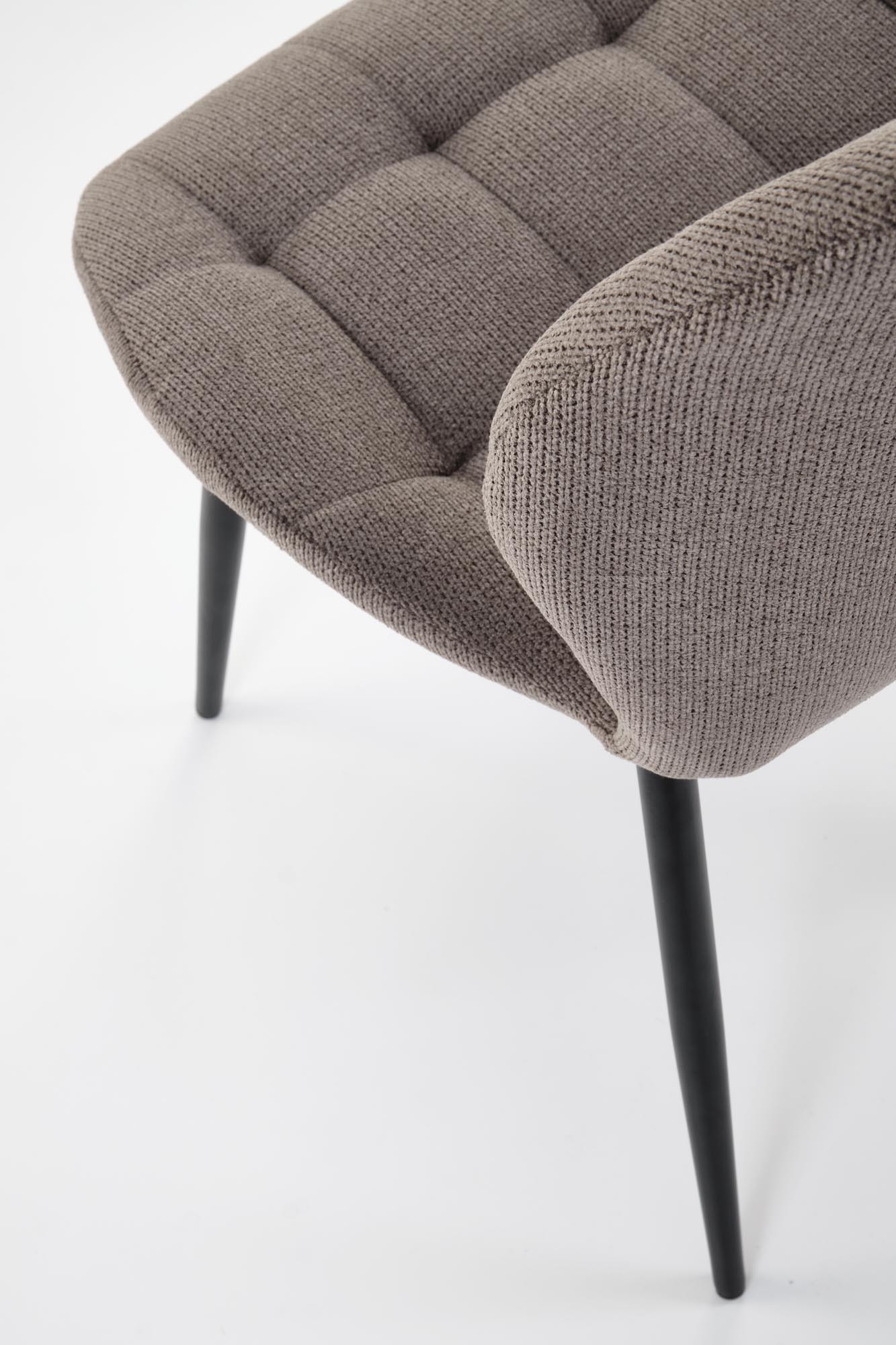 Zbliżenie na popielate, pikowane siedzisko krzesła K548 z czarnymi, stalowymi nogami.