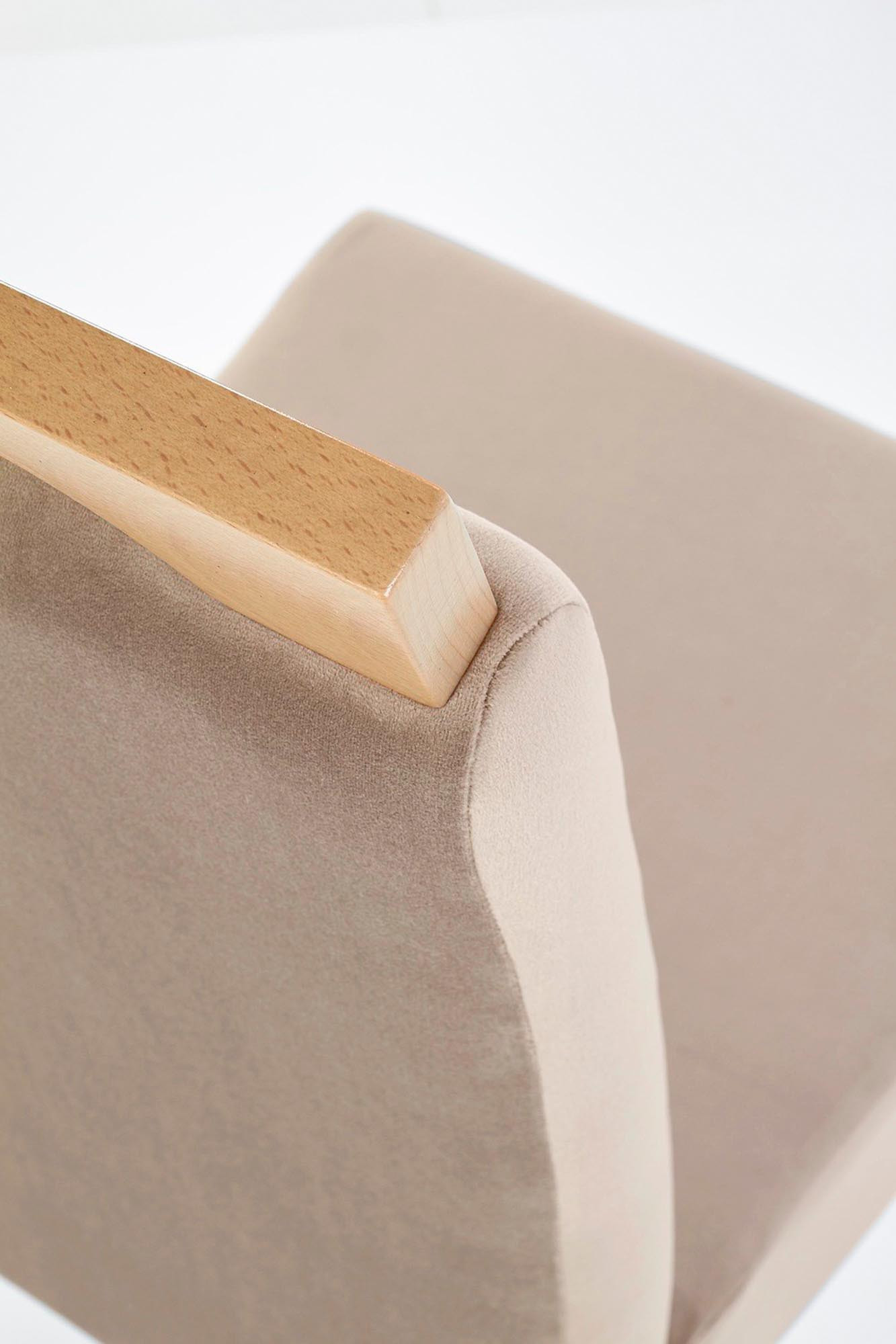 Zbliżenie na jasnobrązowe tapicerowane oparcie krzesła CLARION z drewnianym wykończeniem na górze.