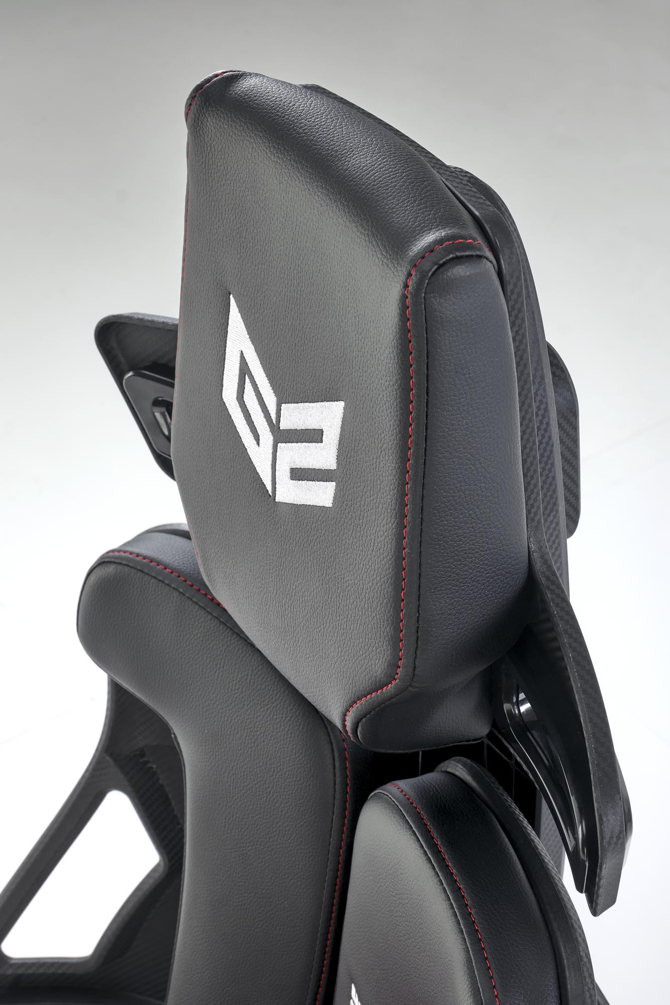Zbliżenie na czarno-czerwone oparcie fotela gabinetowego NITRO z eco skóry z białym logo.
