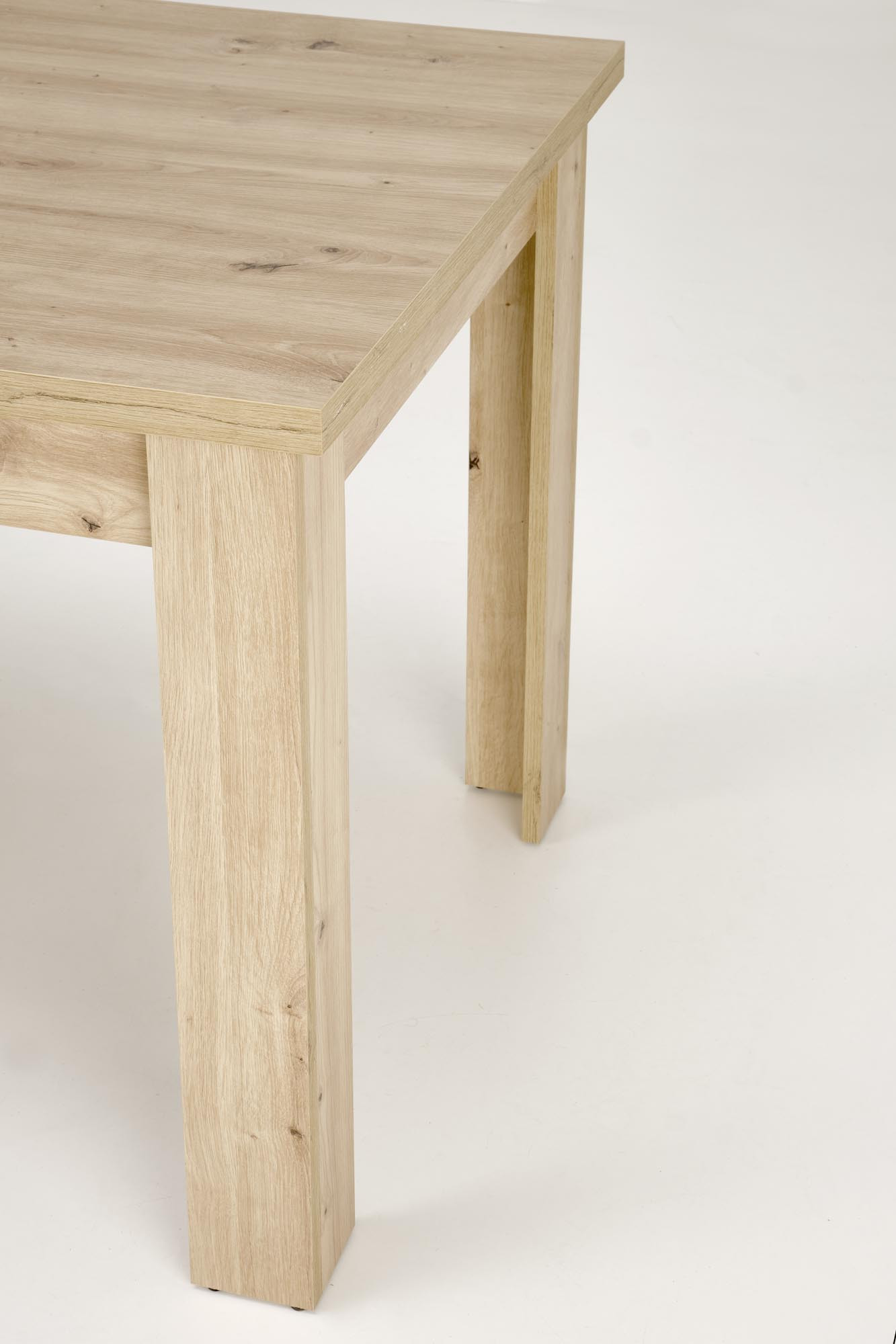 Zbliżenie na nogi rozkładanego stołu BAGIO z dębu artisan.