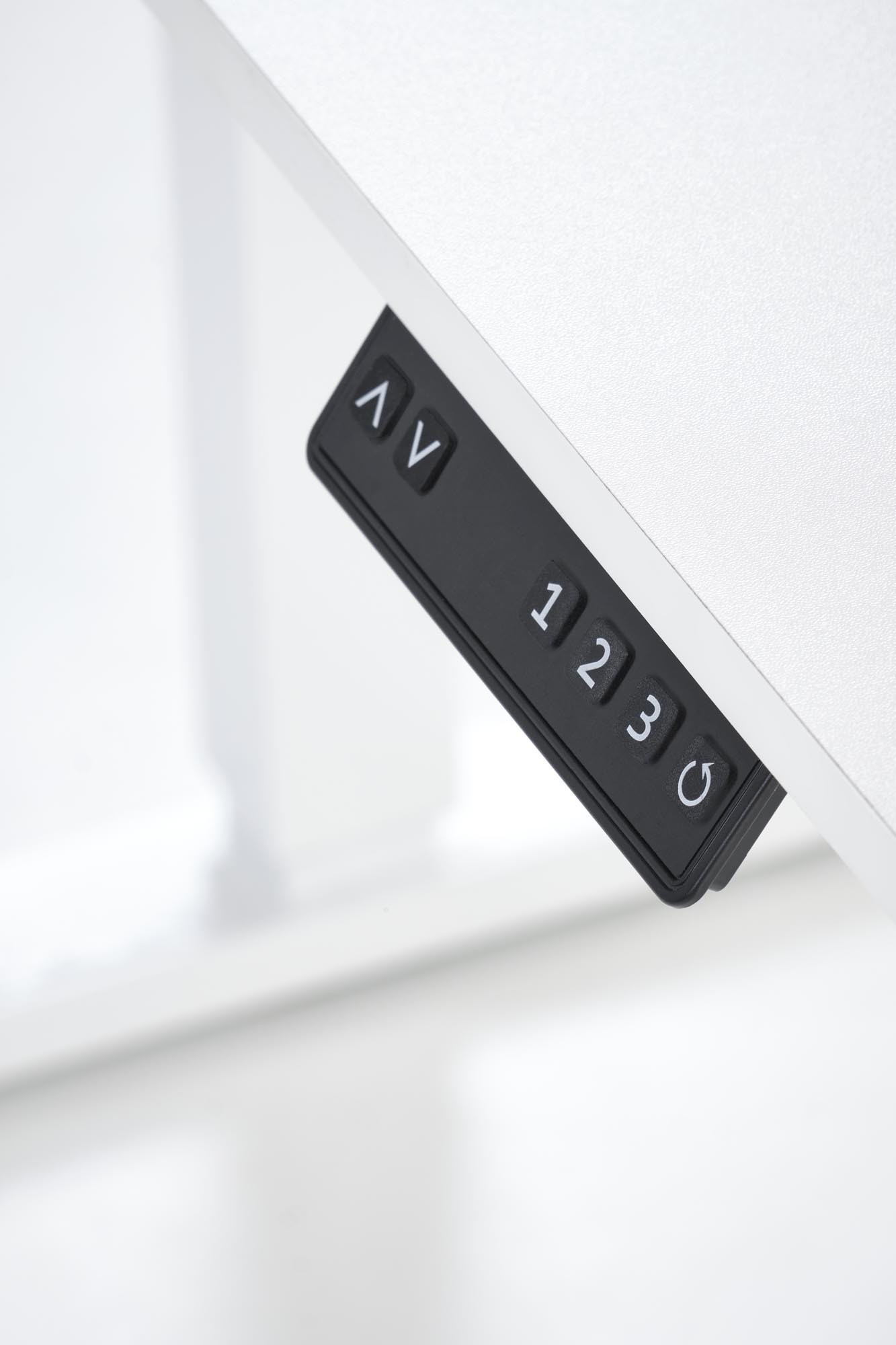 Zbliżenie na panel sterowania elektryczną regulacją wysokości białego biurka B53.