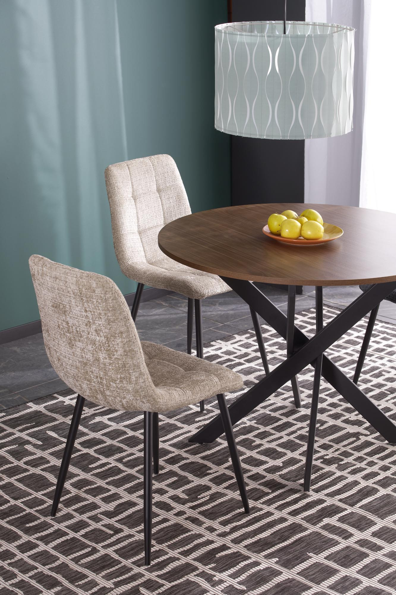 Okrągły stół EDGAR z orzechowym blatem i czarną stalową podstawą – widok z przodu, dwa krzesła obite tkaniną.