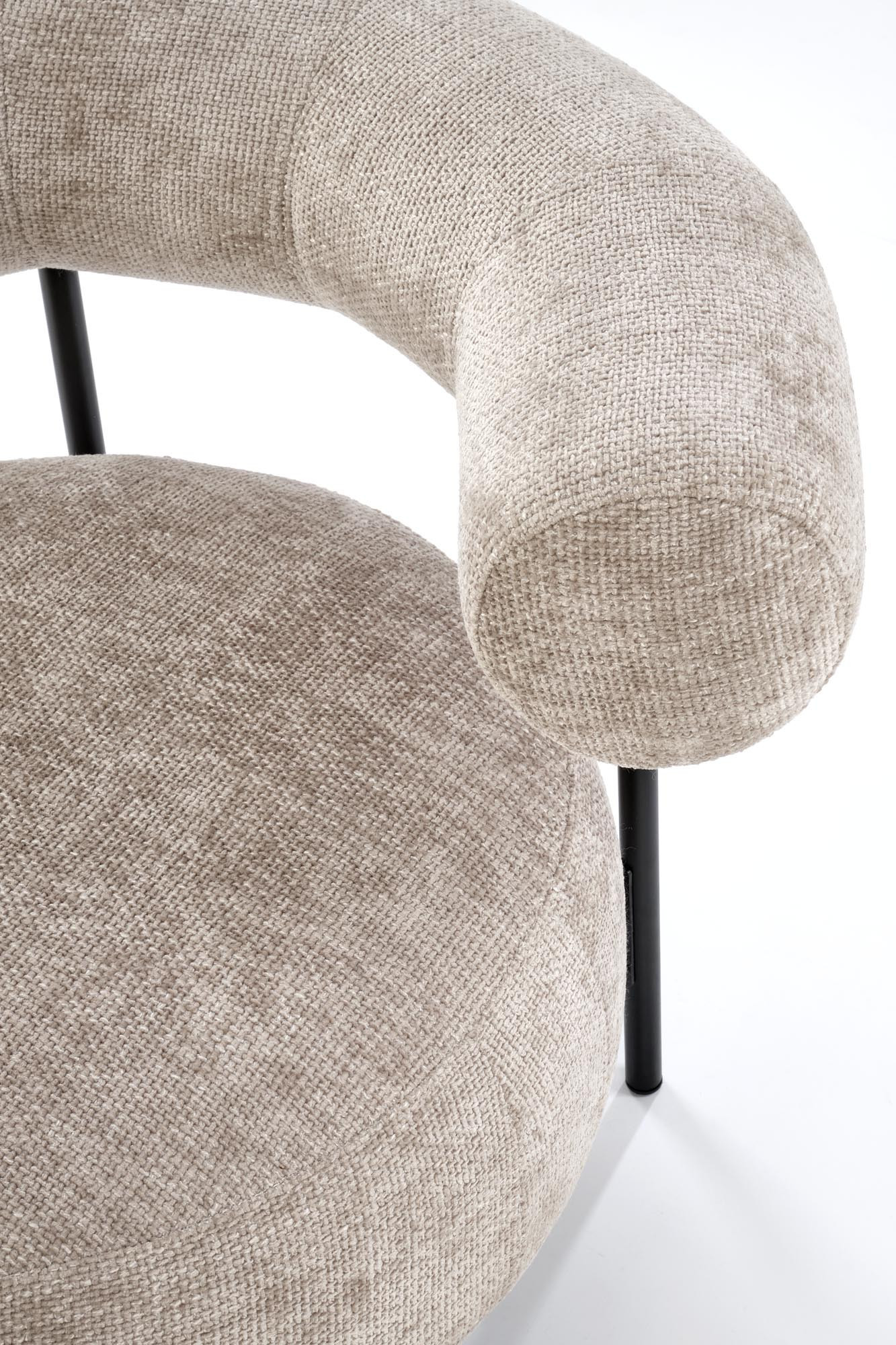 Zbliżenie na zaokrąglone oparcie i siedzisko beżowego fotela HAZARD z tkaniny i stalowymi nogami.