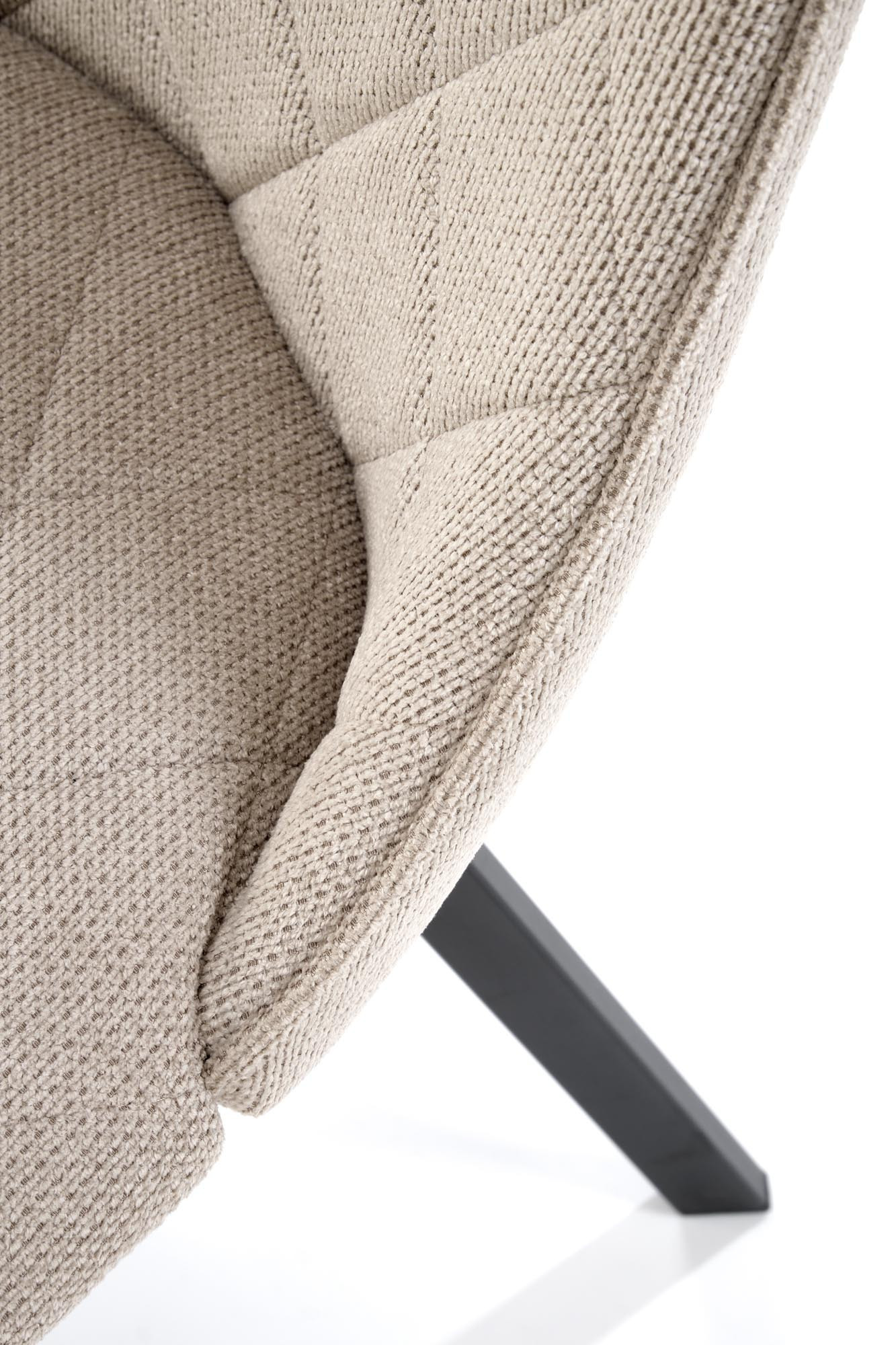 Zbliżenie na pikowaną tkaninę beżowego krzesła K561 z czarnymi stalowymi nogami.