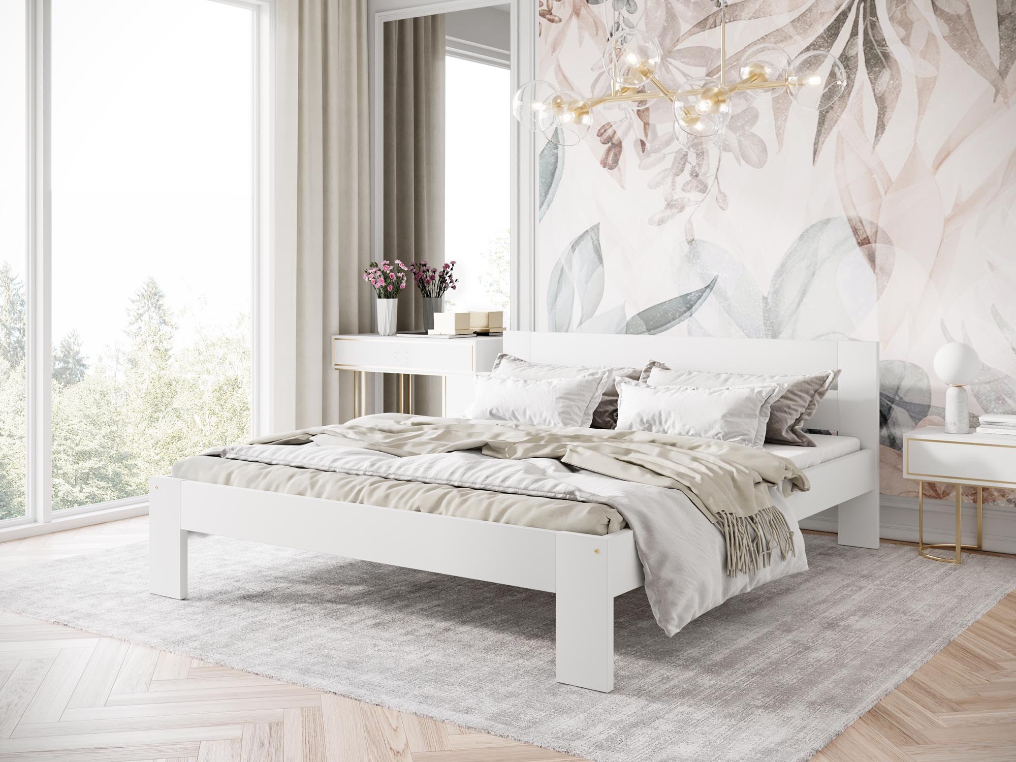 Białe łóżko bukowe MATILDA 160 x 200 cm ze stelażem – widok z przodu w sypialni z roślinną tapetą i dużym oknem.