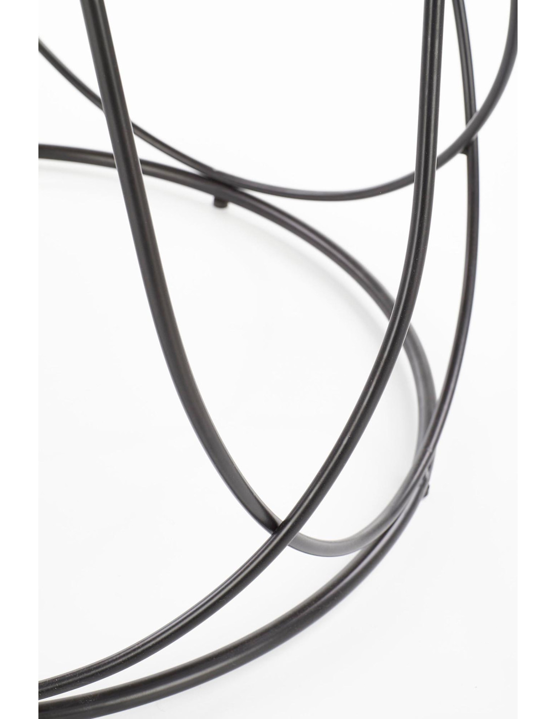 Zbliżenie na czarne metalowe nogi okrągłego stolika NUBIRA z orzechowym blatem.